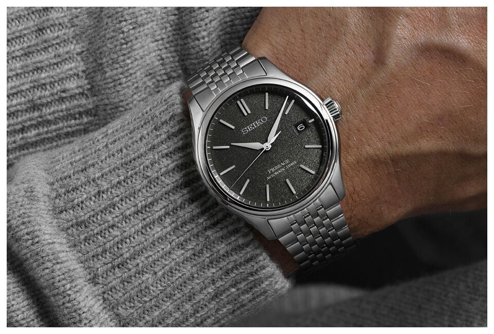 Seiko Presage automatic watch with textured grey dial worn on wrist, stainless steel bracelet and date window